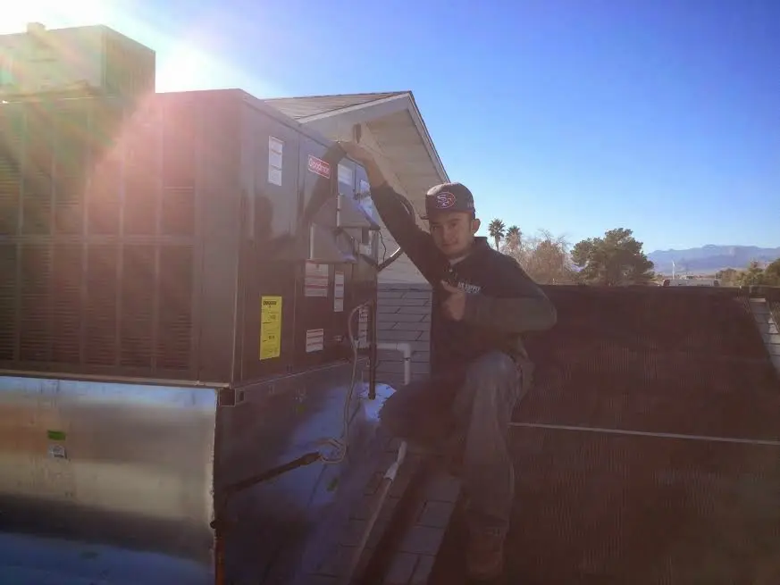 HVAC technician performing HVAC Inspection on a rooftop unit in Franconia